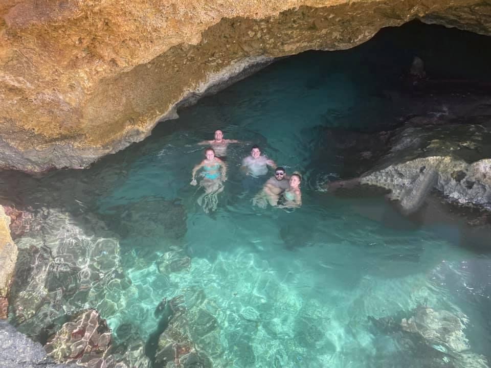 Five friends down below in clear blue water surrounded by rocks